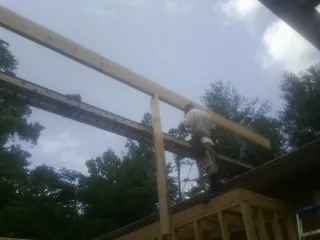 Carpenter setting a ridge beam over a new addition frame — Ice Dam Removal by Roofing Brothers in Danbury
