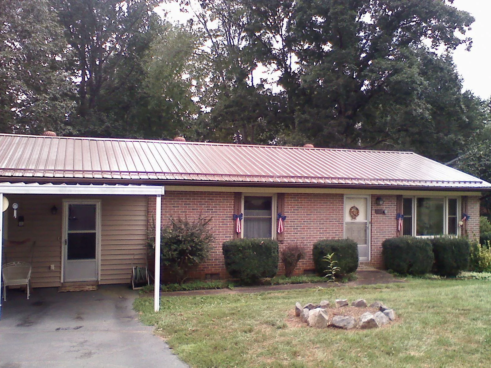 Bronze metal roof and carport on a brick ranch home — Roof Repair work by our crew in Danbury